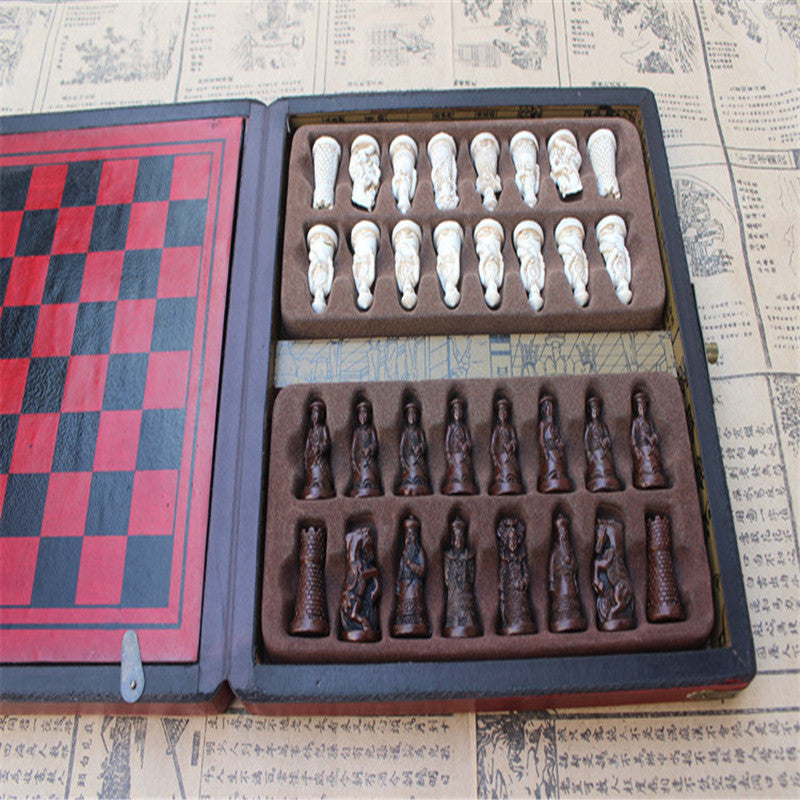 Lifestyle shot of the antique chess set placed on a coffee table beside a stack of books, emphasizing its decorative appeal.

