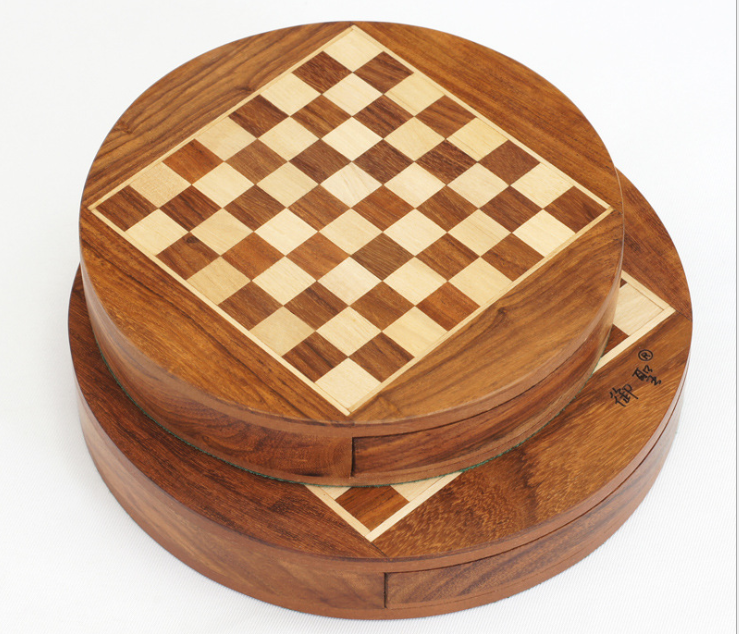 Hands moving a piece on a compact chess board wooden surface