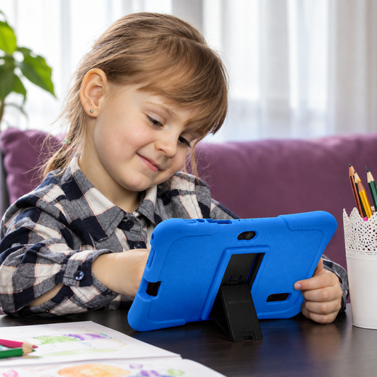 A young girl with light brown hair is sitting at a Learning tablet, smiling while holding a blue protective tablet case with a built-in stand. She is wearing a gray and white plaid shirt, with a purple couch and a white cup of pencils in the background.