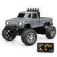 A gray mini RC monster truck with black tires, a front bumper, roof-mounted lights, and a separate black remote control controller shown in the bottom right corner, on a white background.